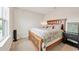Cozy bedroom with warm lighting, a wood frame bed, and neutral décor at 12564 Night View Dr, Sarasota, FL 34238