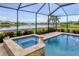 Screened-in pool and jacuzzi with view of the pond with fountain and neighborhood at 12564 Night View Dr, Sarasota, FL 34238