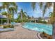 Bright community swimming pool with a covered patio area and lounge seating on a sunny day at 12564 Night View Dr, Sarasota, FL 34238