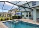 Inviting screened pool area with lounge chairs, umbrella and view of other homes at 12564 Night View Dr, Sarasota, FL 34238
