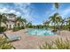 Community swimming pool boasts clear water, mature landscaping, comfortable lounge seating, and a clubhouse at 12564 Night View Dr, Sarasota, FL 34238
