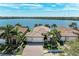 Stunning aerial view of lakefront property with well-maintained landscaping and a beautiful tile roof at 138 Toscavilla Blvd, Nokomis, FL 34275