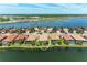 Desirable waterfront home in Nokomis, Florida, boasts lush landscaping and peaceful water views on a bright day at 138 Toscavilla Blvd, Nokomis, FL 34275