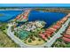 An aerial view of the community highlighting waterfront homes, community pool, clubhouse, and tennis courts at 138 Toscavilla Blvd, Nokomis, FL 34275