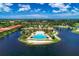Beautiful aerial of the community pool and clubhouse, surrounded by waterfront homes and lush greenery at 138 Toscavilla Blvd, Nokomis, FL 34275