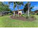 Backyard features lush green lawn, mature trees, tidy landscaping and cozy outdoor seating at 138 Toscavilla Blvd, Nokomis, FL 34275
