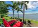 Relax in the sun with tropical palms and peaceful lake views from the backyard lounge chairs at 138 Toscavilla Blvd, Nokomis, FL 34275