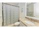 Bathroom showcasing granite countertop vanity, a framed mirror, and a tiled shower with a patterned curtain at 138 Toscavilla Blvd, Nokomis, FL 34275