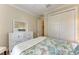 Bright bedroom features neutral walls, a ceiling fan, and a dresser with an adjacent closet at 138 Toscavilla Blvd, Nokomis, FL 34275