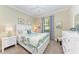 Comfortable bedroom with neutral walls, a large window, ceiling fan, and matching bedside tables at 138 Toscavilla Blvd, Nokomis, FL 34275