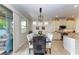 Bright dining room with lake view features a dark wood table, seating for eight, and modern lighting at 138 Toscavilla Blvd, Nokomis, FL 34275