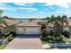 Charming home with well-manicured landscaping, a brick driveway, and a three-car garage at 138 Toscavilla Blvd, Nokomis, FL 34275