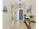 Warm foyer with wood table, tile floors, decorative lighting and front door at 138 Toscavilla Blvd, Nokomis, FL 34275