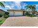 Attractive home with brick driveway, manicured landscaping, and a convenient three-car garage at 138 Toscavilla Blvd, Nokomis, FL 34275
