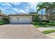 Lovely home with a brick driveway, well-maintained landscaping, and a spacious three-car garage at 138 Toscavilla Blvd, Nokomis, FL 34275
