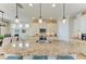 Kitchen showcasing a large granite island, pendant lighting, and modern appliances at 138 Toscavilla Blvd, Nokomis, FL 34275
