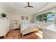 Bright main bedroom with hardwood floors, tray ceiling, and a large window with lake views at 138 Toscavilla Blvd, Nokomis, FL 34275