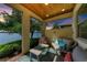 Inviting covered patio with outdoor furniture and peaceful lake views at 138 Toscavilla Blvd, Nokomis, FL 34275