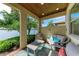 Cozy covered patio features comfortable seating and views of a tranquil lake at 138 Toscavilla Blvd, Nokomis, FL 34275