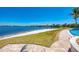 Stunning waterfront view with lush landscaping and a beautiful blue pool in the background at 138 Toscavilla Blvd, Nokomis, FL 34275
