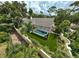 Aerial view of the property showcases a screened-in pool, lush landscaping, and manicured lawn at 140 Sugar Mill Dr, Osprey, FL 34229