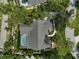 Overhead view of property featuring a screened-in pool, well-maintained roof, and mature trees at 140 Sugar Mill Dr, Osprey, FL 34229