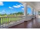 Beautiful golf course view from covered balcony with columns and brick flooring at 140 Sugar Mill Dr, Osprey, FL 34229