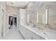 Elegant bathroom featuring double sinks, white countertops, stylish mirrors, and access to a walk-in closet at 140 Sugar Mill Dr, Osprey, FL 34229
