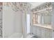 Bathroom features tub, shower and single sink with granite vanity, all accented by elegant floral wallpaper at 140 Sugar Mill Dr, Osprey, FL 34229