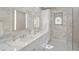 Bright bathroom featuring double sinks, white marble countertops and modern fixtures, adjacent to glass shower enclosure at 140 Sugar Mill Dr, Osprey, FL 34229