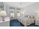 Cozy bedroom with two twin beds, colorful floral bedding, and windows for natural light at 140 Sugar Mill Dr, Osprey, FL 34229