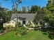 Attractive single-story home with a manicured lawn and colorful garden at 140 Sugar Mill Dr, Osprey, FL 34229