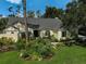 Attractive single-story home with a manicured lawn and colorful garden at 140 Sugar Mill Dr, Osprey, FL 34229