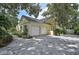 Spacious three-car garage with a brick driveway and well-maintained landscaping at 140 Sugar Mill Dr, Osprey, FL 34229