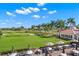 Golf course view from patio with tables, chairs and sun umbrellas under blue sky at 140 Sugar Mill Dr, Osprey, FL 34229