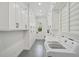 Bright laundry room features ample cabinet space, a modern washer and dryer, and sleek gray flooring at 140 Sugar Mill Dr, Osprey, FL 34229