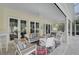 Cozy covered patio area features comfortable seating, ceiling fans, and views of the pool and backyard at 140 Sugar Mill Dr, Osprey, FL 34229