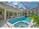 Screened-in pool and spa area with ample seating and a view of lush landscaping at 140 Sugar Mill Dr, Osprey, FL 34229