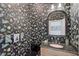 Stylish powder room with black floral wallpaper, granite sink and classic fixtures at 140 Sugar Mill Dr, Osprey, FL 34229