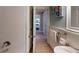 Bathroom with white subway tile shower and decorative ocean-themed artwork in hallway at 152 Coolidge Dr, Sarasota, FL 34236