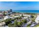 Scenic aerial view of a coastal town featuring beachfront condos, lush greenery, and an expansive ocean at 160 Coolidge Dr, Sarasota, FL 34236