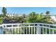 Relaxing balcony view over tropical foliage and nearby condos with blue skies in the distance at 160 Coolidge Dr, Sarasota, FL 34236