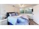 Comfortable bedroom with ceiling fan, dark hardwood floors, and bright sunny window at 160 Coolidge Dr, Sarasota, FL 34236