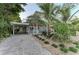 Charming two-story home with tropical landscaping, brick driveway, and covered parking at 160 Coolidge Dr, Sarasota, FL 34236