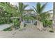 Charming two-story home with tropical landscaping and a walkway with boulder accents at 160 Coolidge Dr, Sarasota, FL 34236