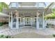 Inviting front porch with comfortable seating, stylish lighting, and a brick paved walkway at 160 Coolidge Dr, Sarasota, FL 34236