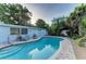 Gorgeous pool area with lounge chairs, a grill and lush landscaping in the backyard at 160 Coolidge Dr, Sarasota, FL 34236