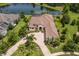An aerial view of an estate home with a tile roof, circular drive, and a private lake view at 16531 Kendleshire Ter, Lakewood Ranch, FL 34202