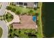 Overhead aerial view of a home with pool, landscaped yard, brick driveway, and lake view at 16531 Kendleshire Ter, Lakewood Ranch, FL 34202