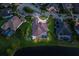 Scenic aerial view of a property with pool, lush landscaping, and lakefront access at dusk at 16531 Kendleshire Ter, Lakewood Ranch, FL 34202